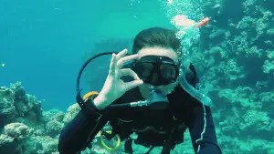Diver captured underwater in a high-angle camera shot, demonstrating how a diving shot frames the subject from above to show scale and depth, before editing and hosting on Cinema8.